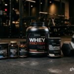 Os melhores suplementos para musculação dispostos ao lado de equipamentos de academia para maximizar resultados